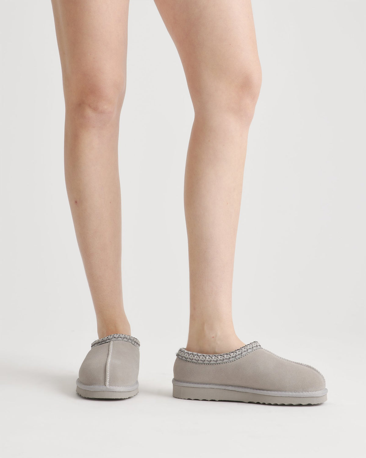 Pantoufles-sabots gris clair portées, vue des jambes