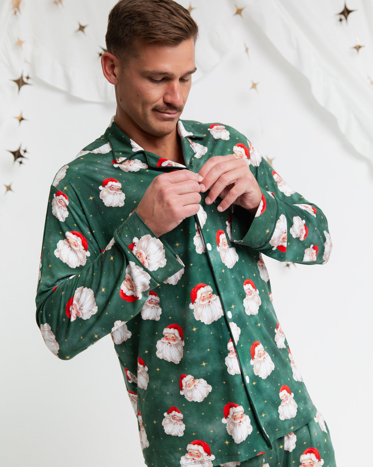 Homme boutonnant la chemise à col du pyjama de Noël à motif de Père Noël