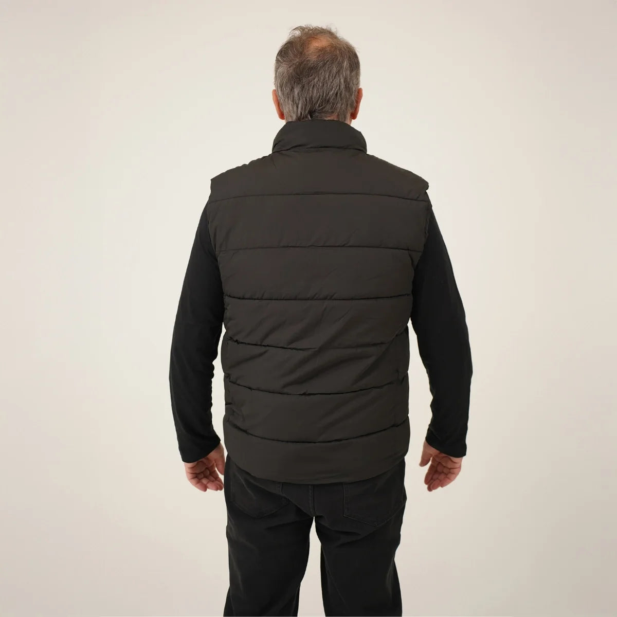 Veste chauffante sans manches portée par un homme, vue de dos