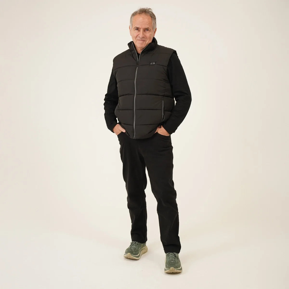 Homme portant la veste chauffante sans manches, mains dans les poches