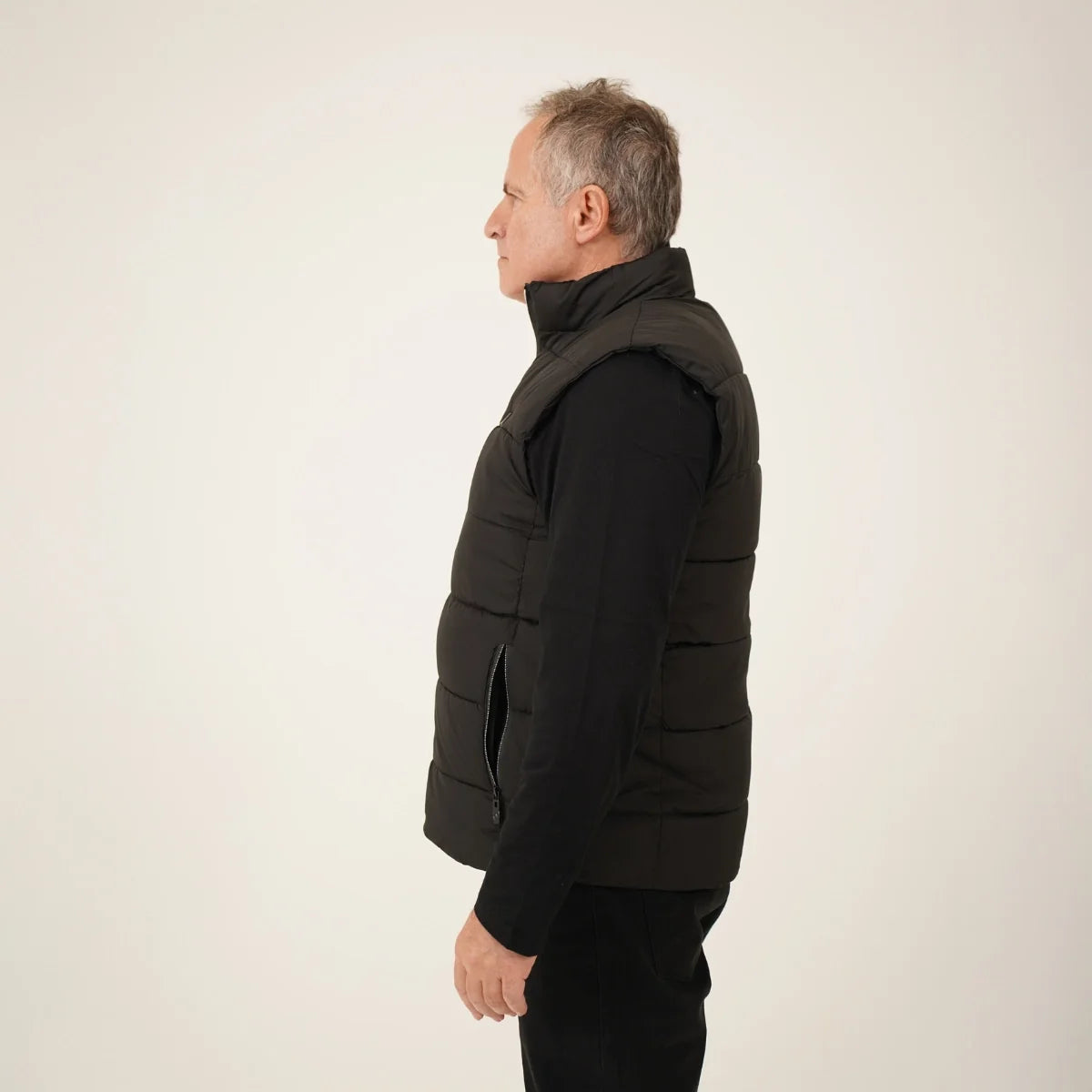 Veste chauffante sans manches portée par un homme, vue de profil